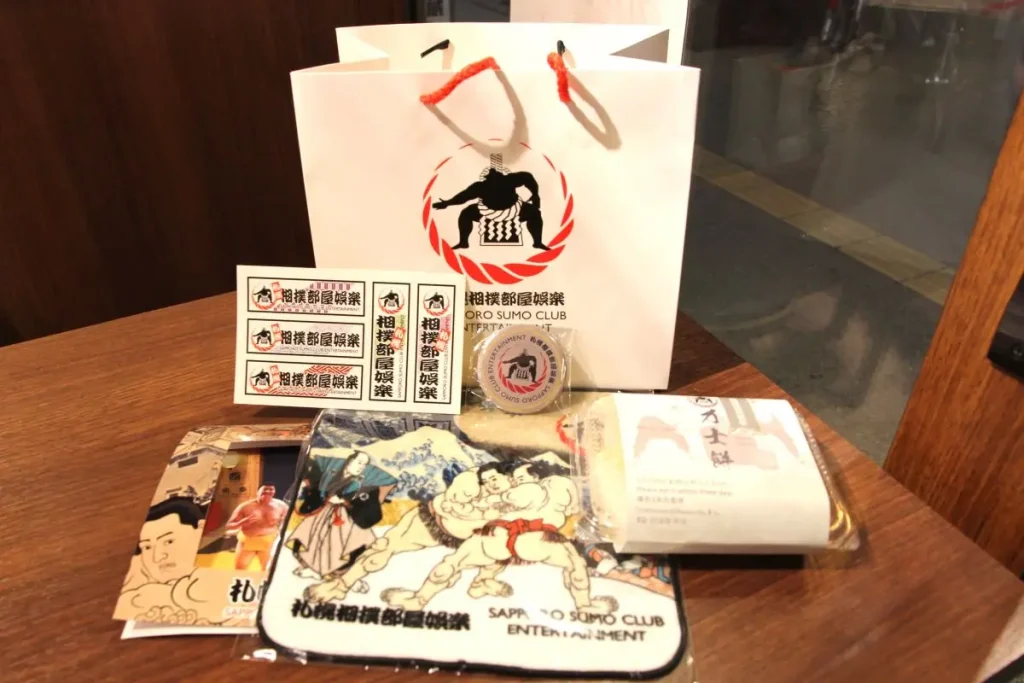 Souvenirs including the photo taken with the wrestlers, the mochi pounded during the show, and other original goods.