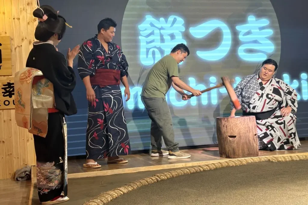 A guest participating in mochi pounding after the wrestlers’ demonstration.