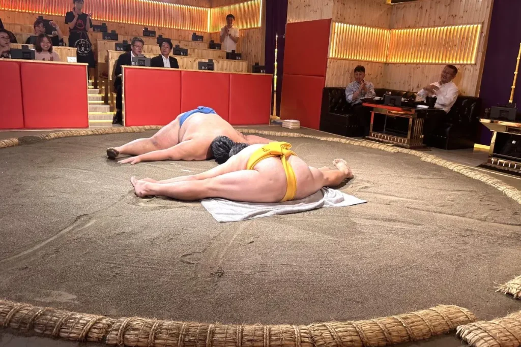 Showing the wrestler’s flexibility with mata-wari (middle splits).