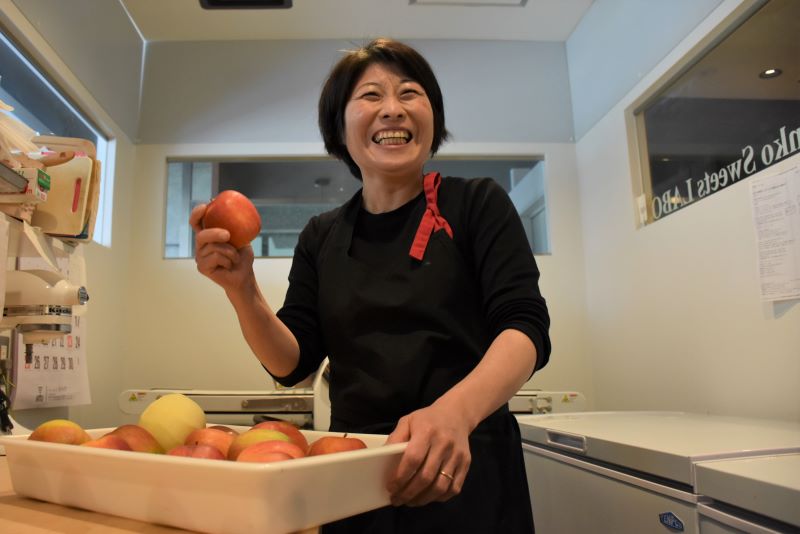 リンゴを手に笑顔を見せる金田さん