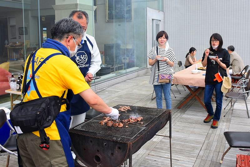 ２つに切ったドラム缶を使い、「焼き床」と呼ばれるバーベキューを楽しむ様子