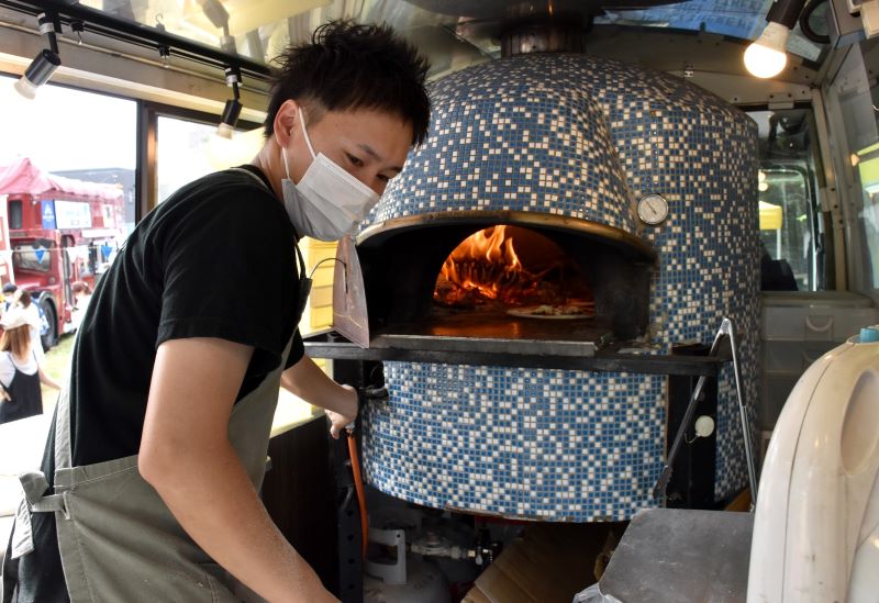 キッチンカーに搭載した石窯でピザを焼く宮本さん