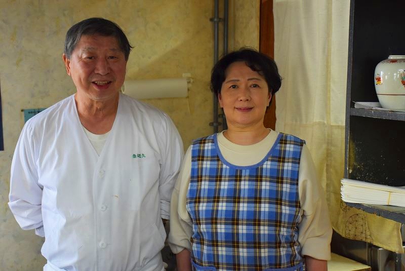 「郷土料理　奈辺久（なべきゅう）」の大将の飯塚隆司さん（左）と女将の優子さん