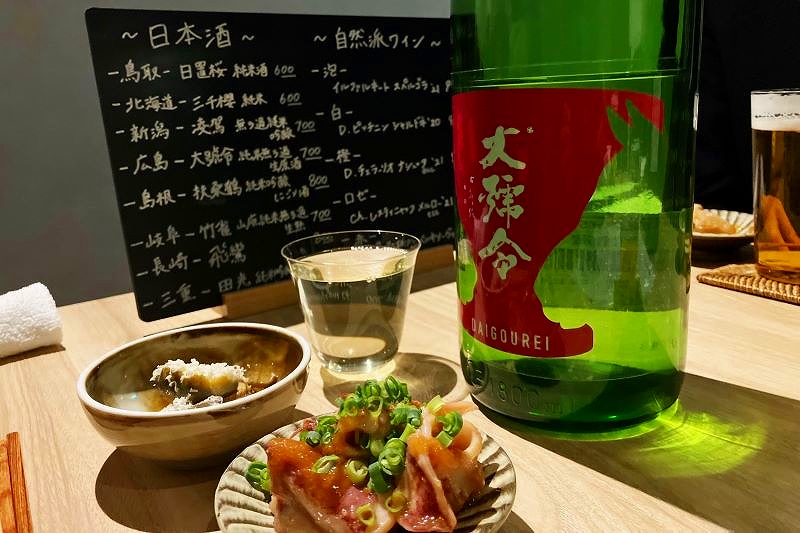 テーブルに置かれた日本酒の瓶やグラス、料理