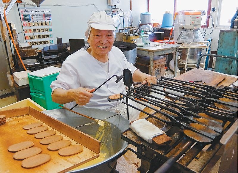 創業時からの道具でせんべいを手焼きする「我国（わがくに）煎餅店」の佐々木さん