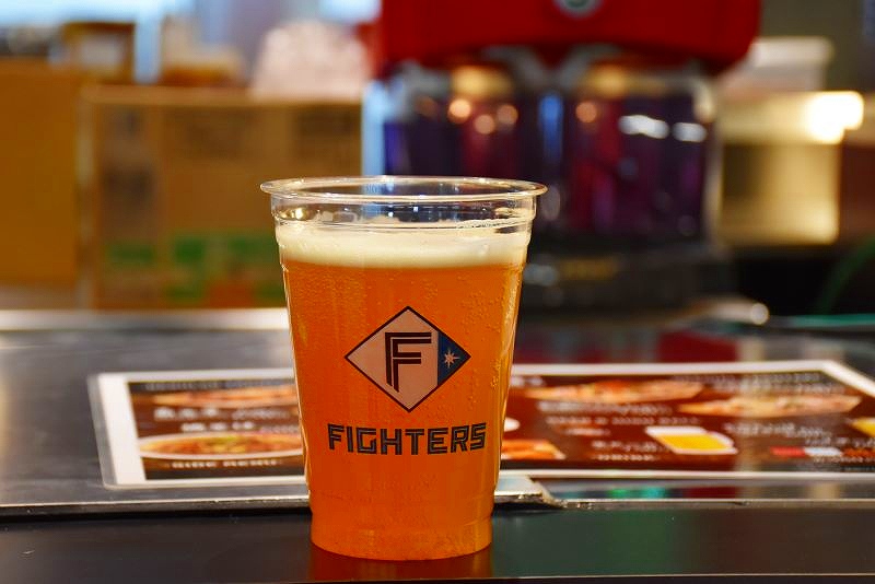 「エスコンフィールド北海道」で提供される、ファイターズのロゴ入りカップに注がれたビール