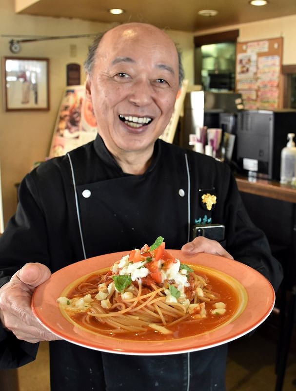 「レストラン　はまなす」で一番人気のモッツアレラチーズのスパゲティを手にする谷口修さん