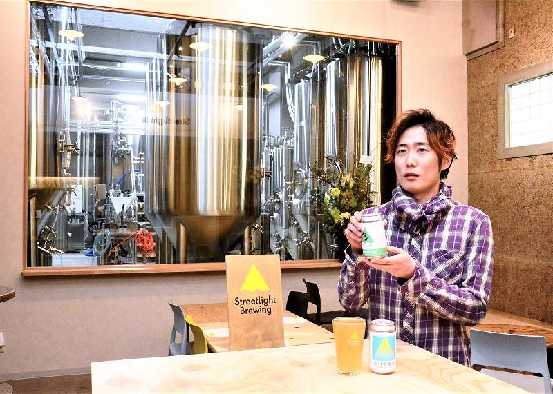 後方に見える醸造タンクの前で、ビールへの思いを語る「札幌醸々（じょうじょう）」の宮口晃一さん