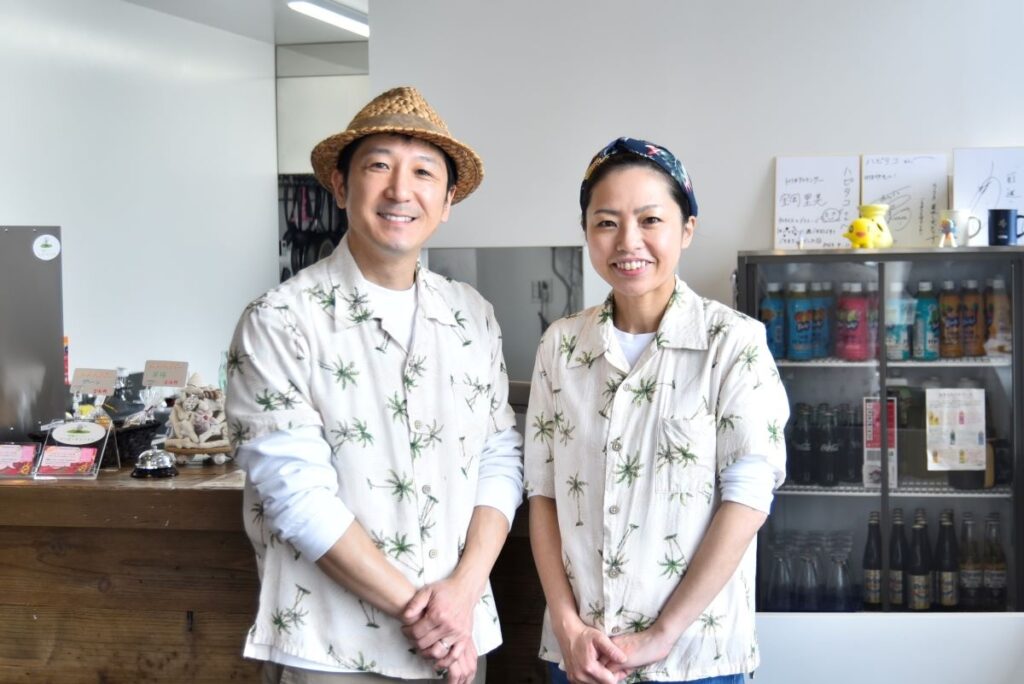 店内で笑顔を見せる「ハッピータコライス」のオーナーの小山内基さん（左）と紗綾乃さん（右）夫妻