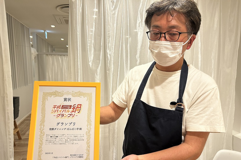 コンテストのグランプリ受賞の盾を持つ「ぽんぽこ亭」店主の吉川さん