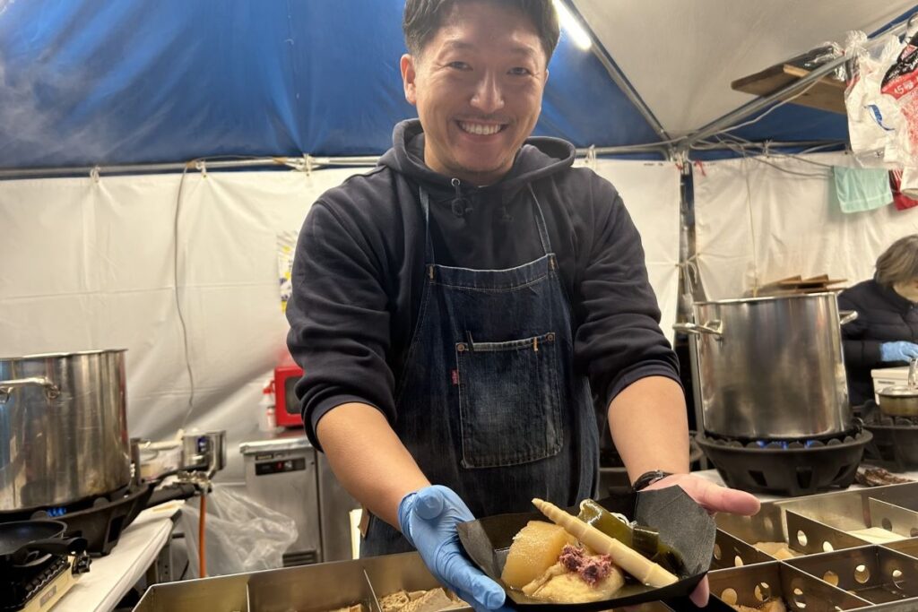 笑顔でおでんを出す「おでん屋えんちゃん」のスタッフ