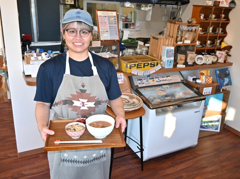 人気の「お雑煮おこわセット」を持つ辰巳さん