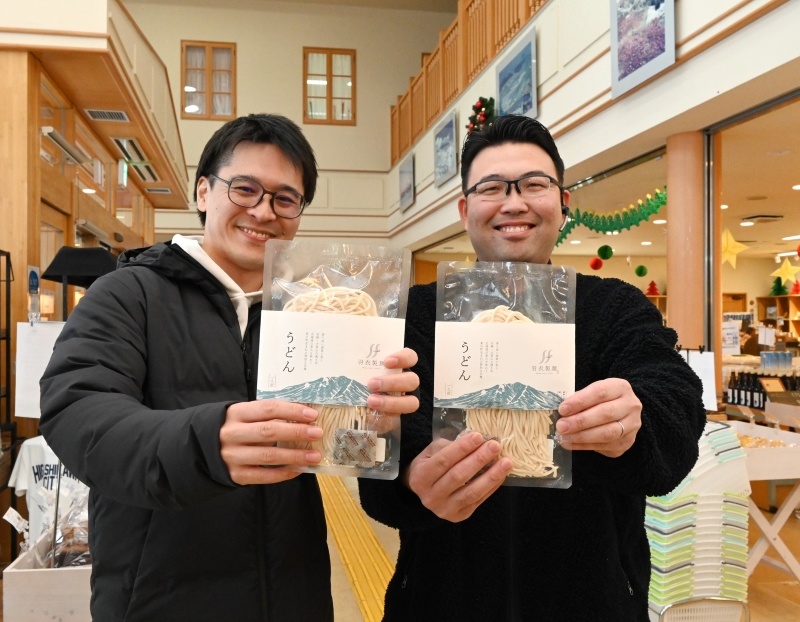 道の駅で一般販売を始めたうどんを手にする寺林幸一さん（右）と中谷太一さん