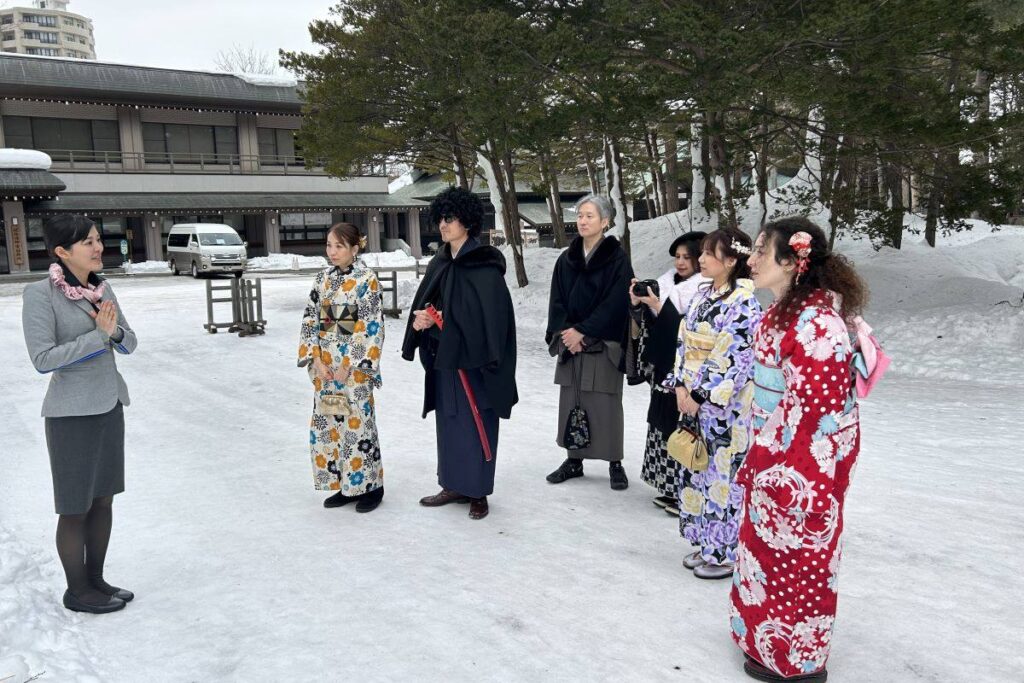 ANAのCA小林さん（左）の案内で北海道神宮の境内を散策する参加者