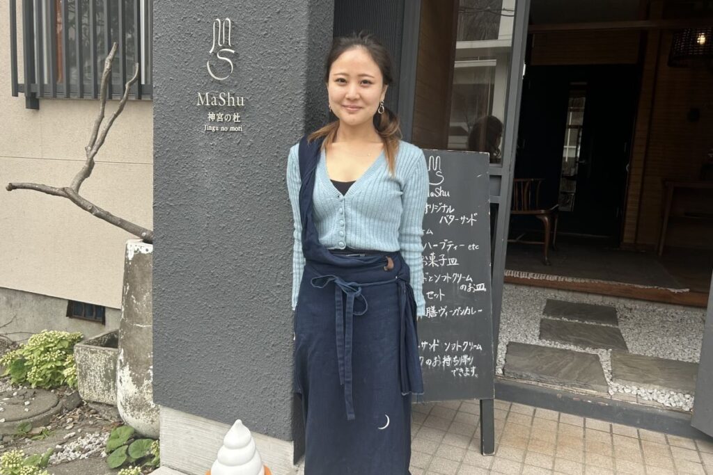 「マシュー神宮の杜」店舗前で笑顔を見せるマネージャーの吉岡真花さん