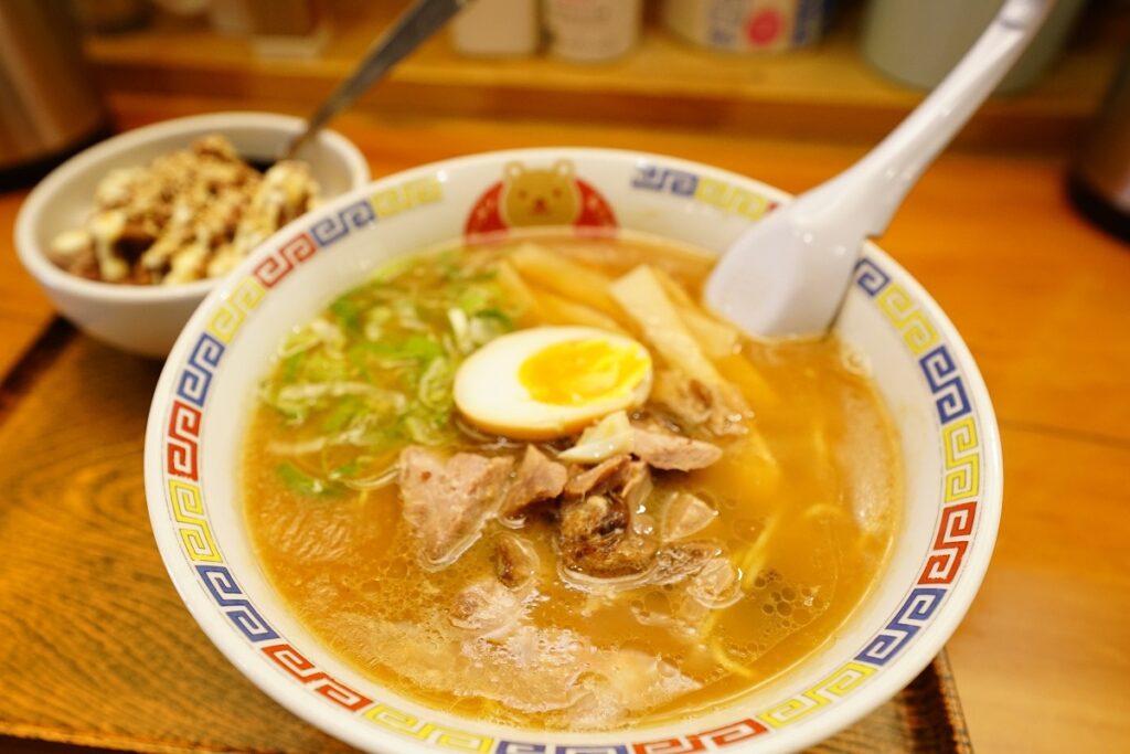 鶏ガラと豚骨のダブルスープの表面に焦がしラードの膜が浮く、「こぐまん」のラーメン