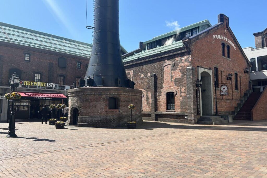 REWERY1876（左）とビールを醸造している醸造所（右）。中央は広場の名前の由来になっている煙突