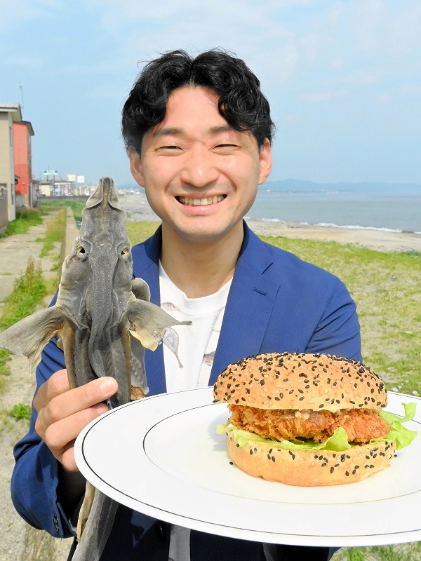 お皿に乗せた「函館サメフライバーガー」をＰＲする福田海産の斉藤いゆさん