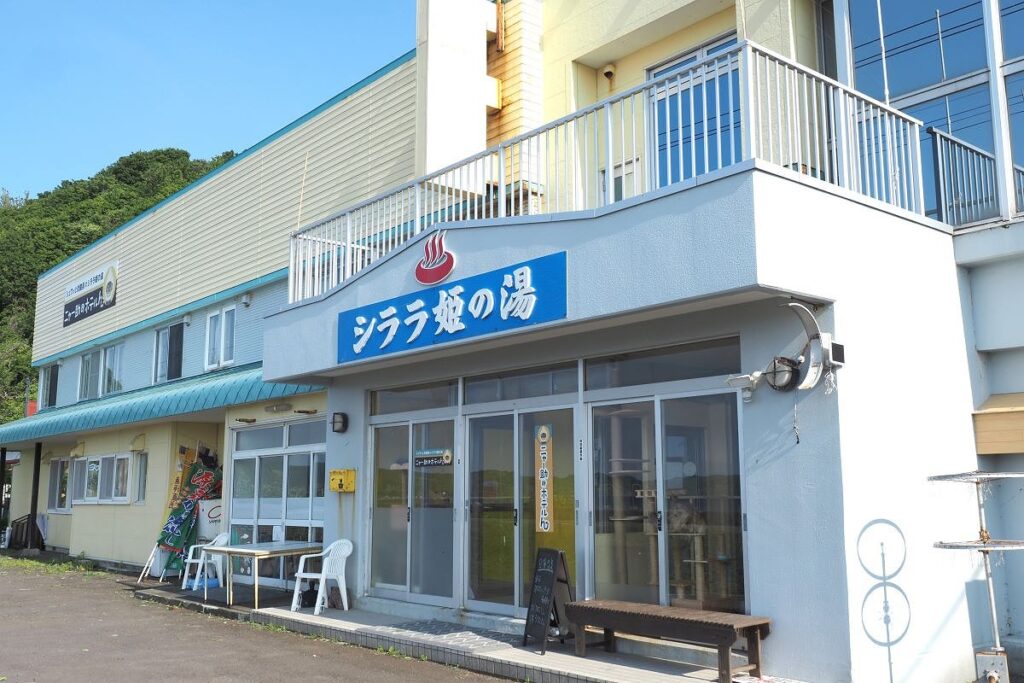 「シララ姫の湯」という別名も看板として掲げられている｢ニャー助のホテルん｣外観