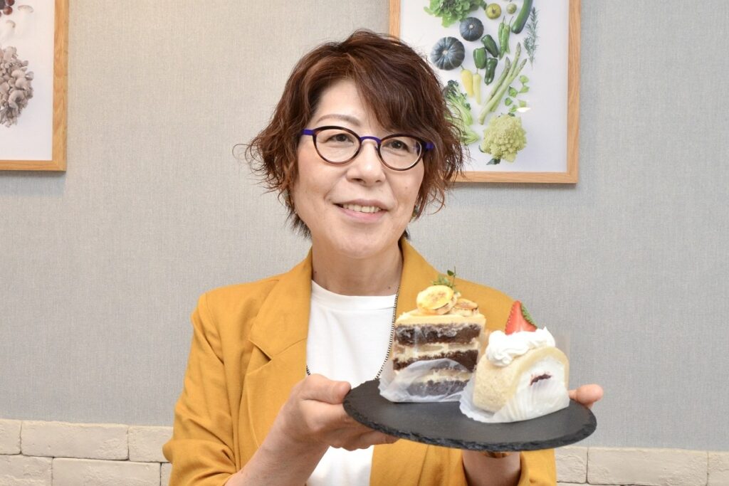 グルテンフリー、ナッツフリーのケーキを手にする安藤さん