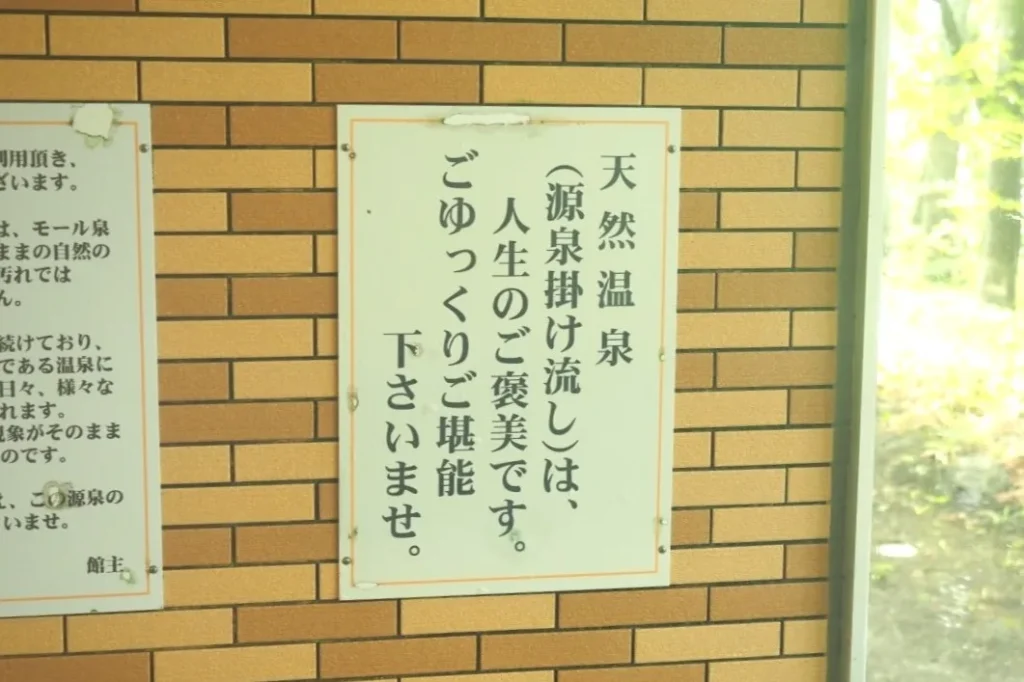 ぬる湯の湯船脇に掲げられた「天然温泉は、人生のご褒美です」