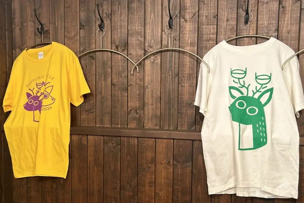 スタッフが来ていたワインサークルの今年のTシャツ（左）と昨年のＴシャツ