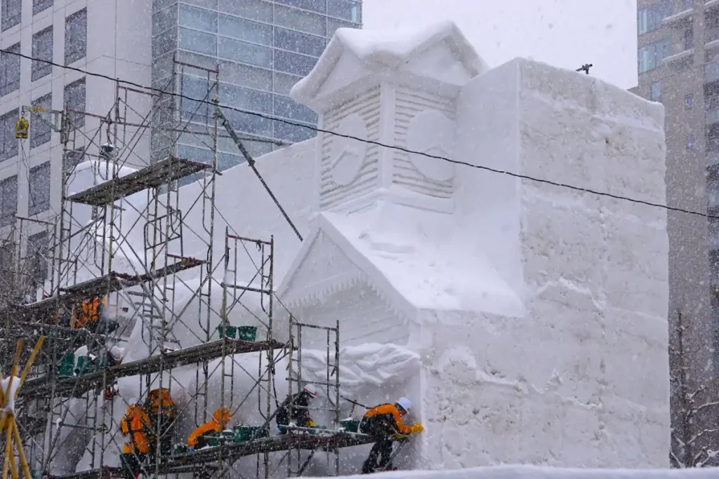 雪の舞う中で５丁目で進む[
札幌へ駆けるサラブレッド」雪像の製作作業