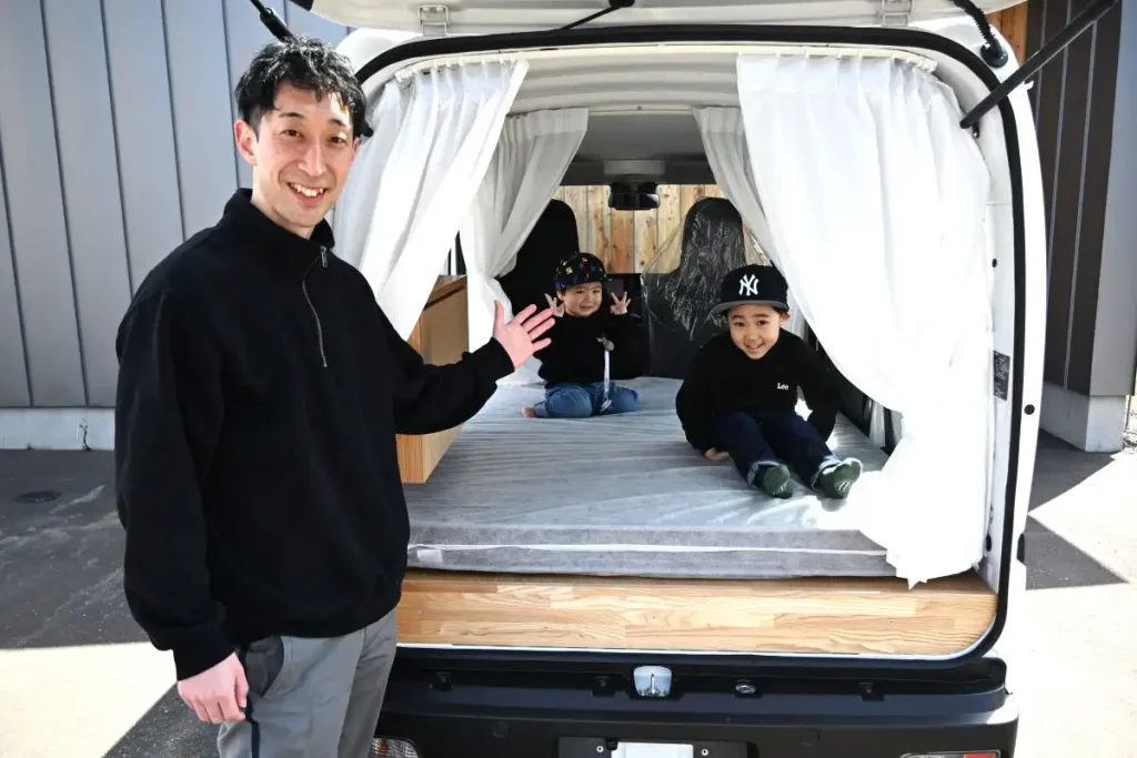 車中泊できるように改装した軽バン自動車。左は木村社長