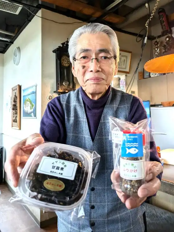 室蘭産ヤヤンコンブを活用した新商品の甘露煮(左)とふりかけを手にする関根代表