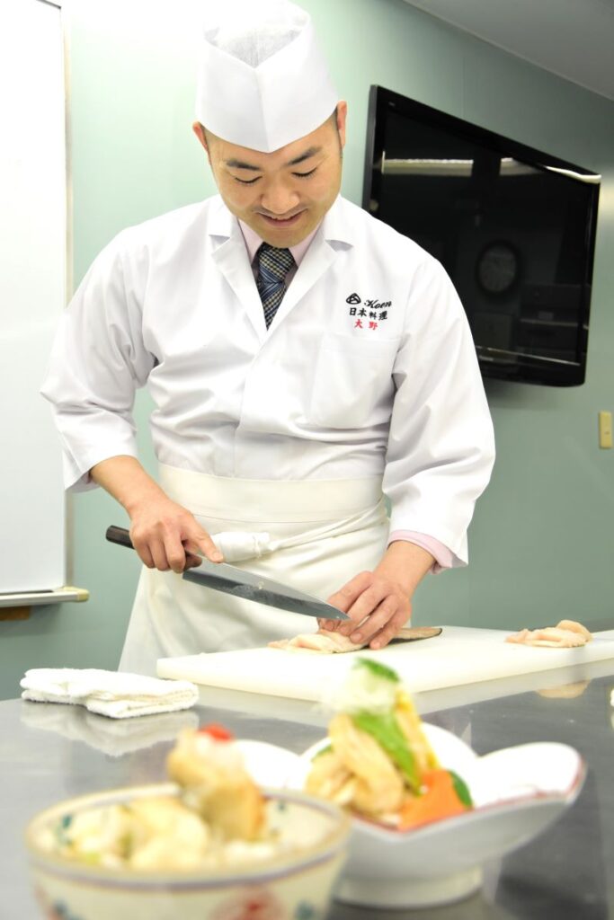 ホッケの骨を切りながら身に切り込みを入れる大野浩平さん