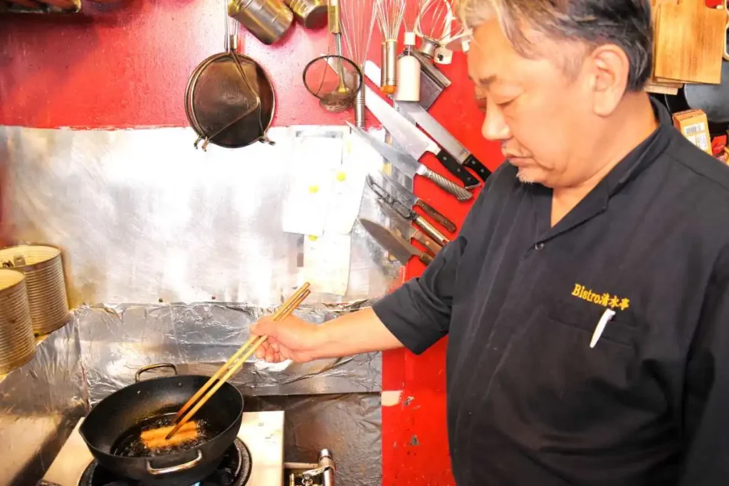 オオズワイガニの春巻きを揚げる清水さん