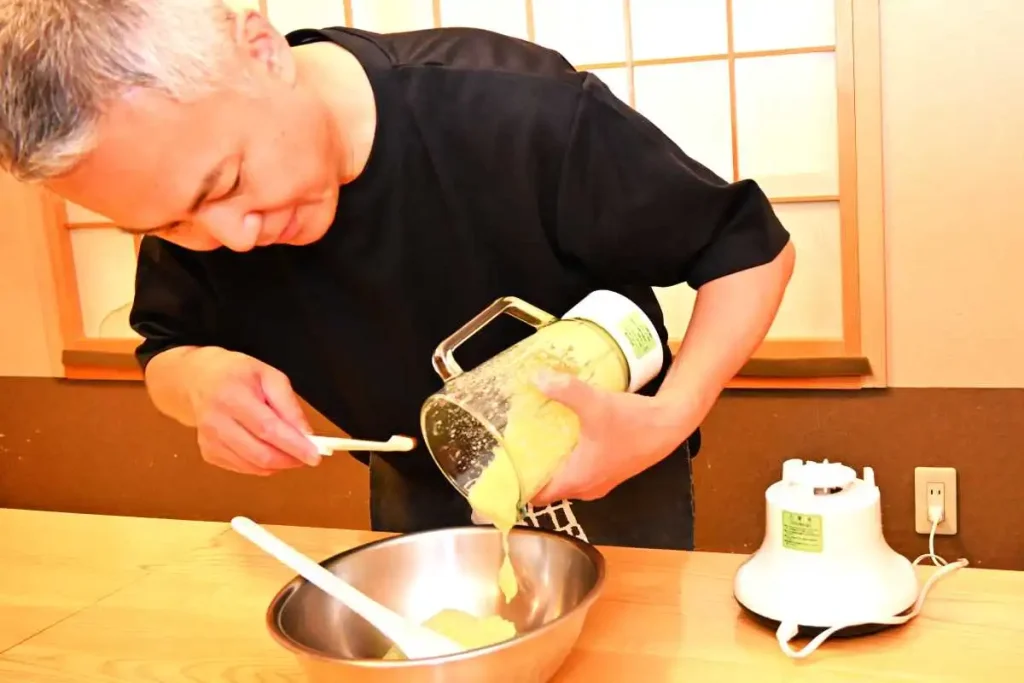 ミキサーにかけた枝豆を卵白と合わせる三谷さん