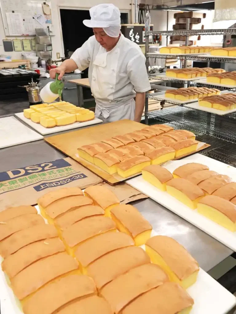 焼き上がったスポンジケーキ。地酒の福司を吹きかけていく(小松巧撮影)