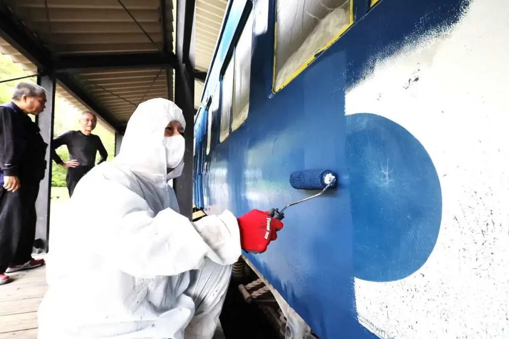 鉄道車両にペンキを上塗りする中村光司さん