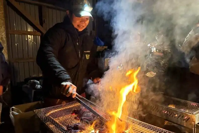 解体したエゾシカ肉を炭火で焼く大野さん