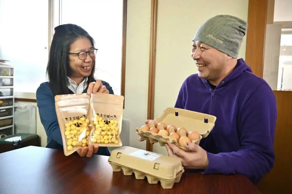 おのたまを使った「たまごぼーろ」を手に笑顔を見せる佐藤さん（左）と小野さん