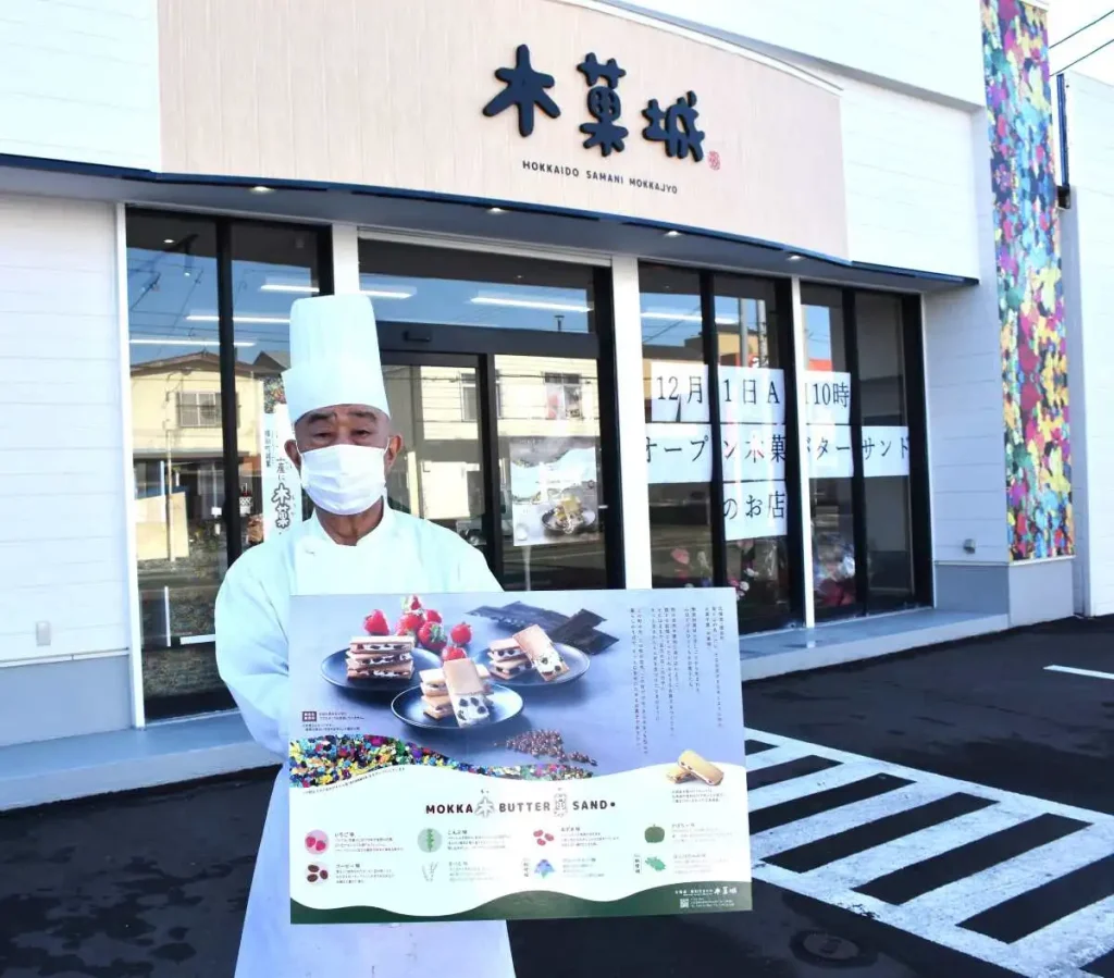 12月1日にオープンした木菓城の店舗の前で、スイーツをPRする佐藤さん